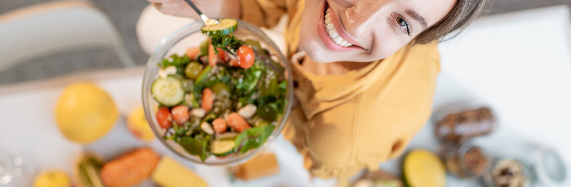 Frau mit Gemüse-Schale lächelt